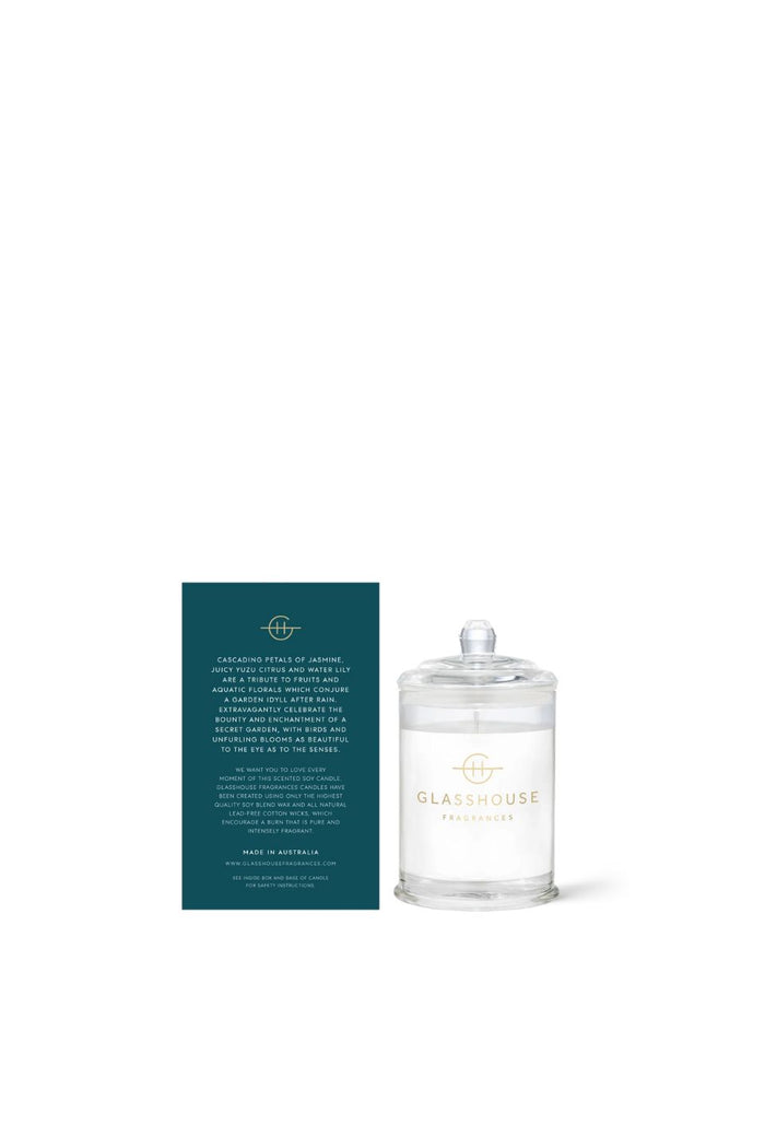 Glass candle with a label next to it on a white background