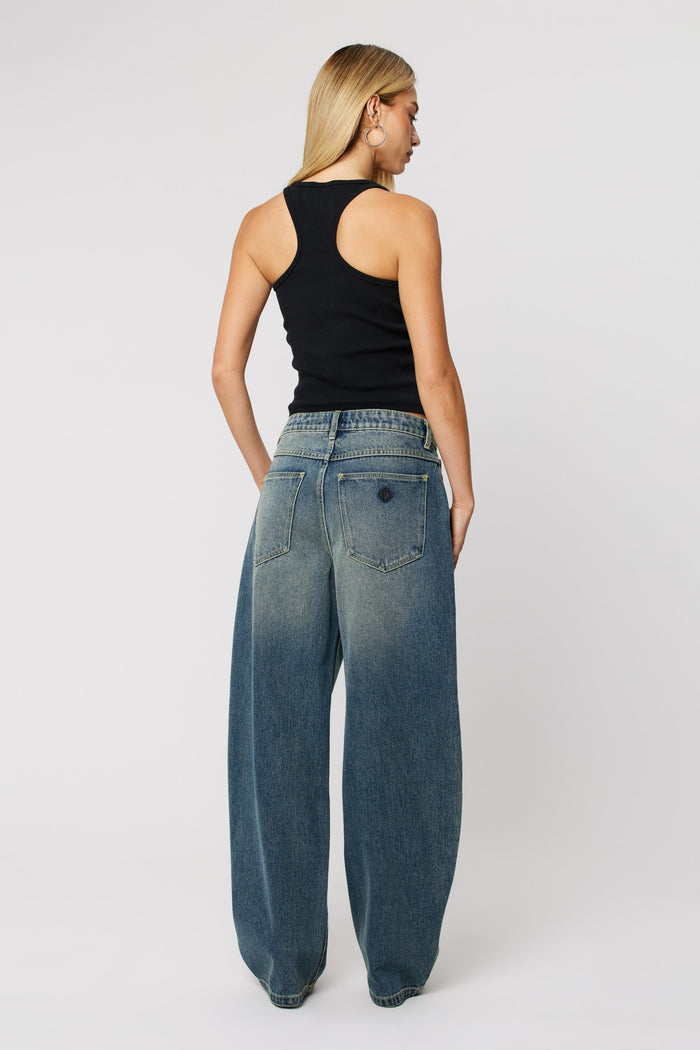 Woman wearing dark wash denim blue jeans with wide leg
