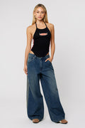 Woman wearing dark wash baggy jeans with a side stripe