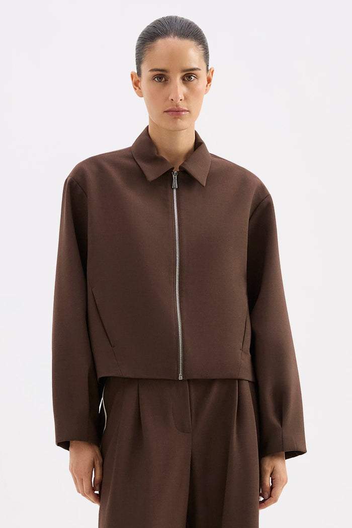 Person wearing a brown outfit on a white background