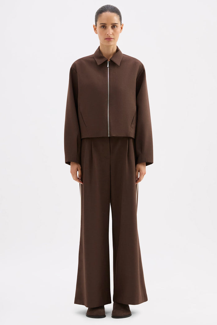 Person wearing a brown outfit on a white background