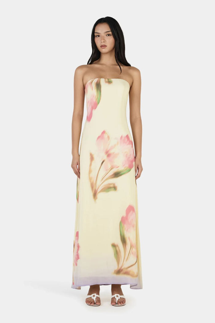 Woman wearing a strapless floral dress on a white background