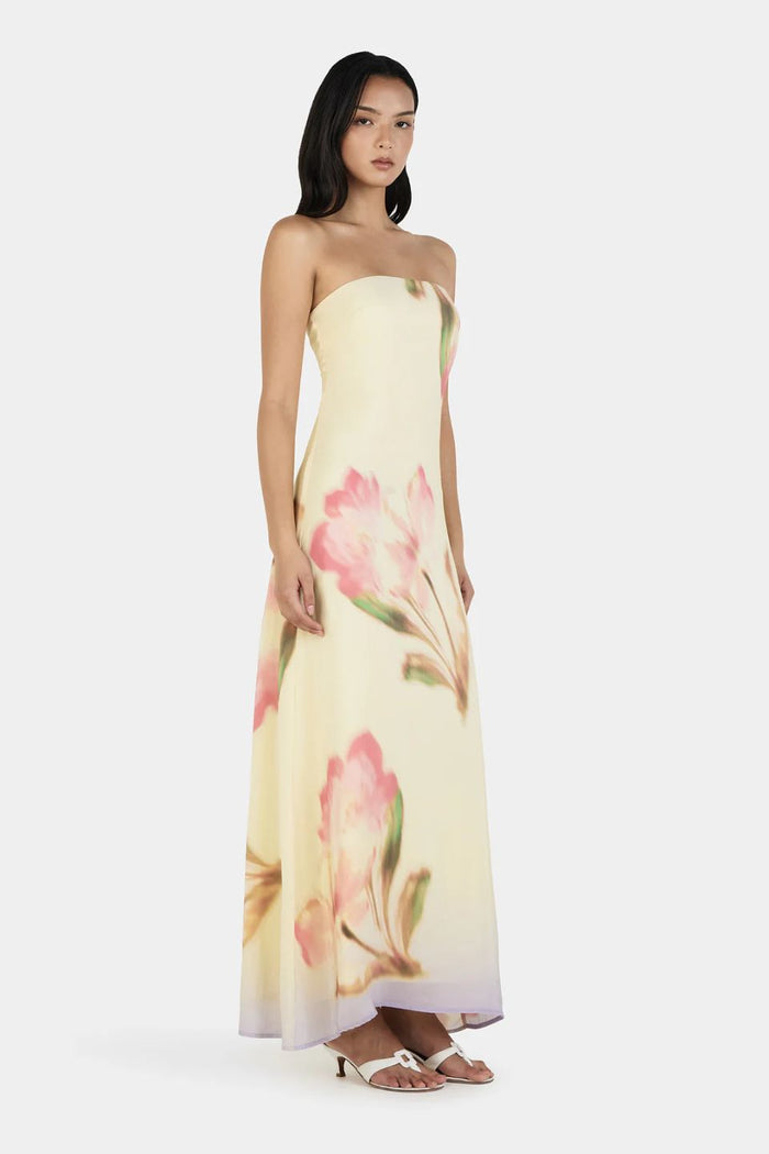 Woman wearing a strapless floral dress on a white background