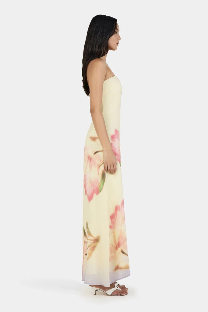 Woman wearing a floral strapless dress on a white background