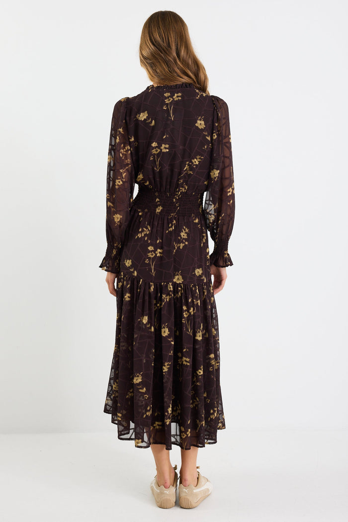 Woman wearing a dark floral dress on a white background