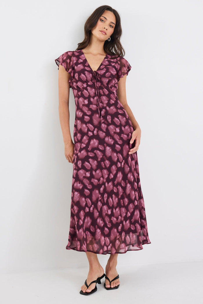 Woman wearing a purple floral dress on a white background