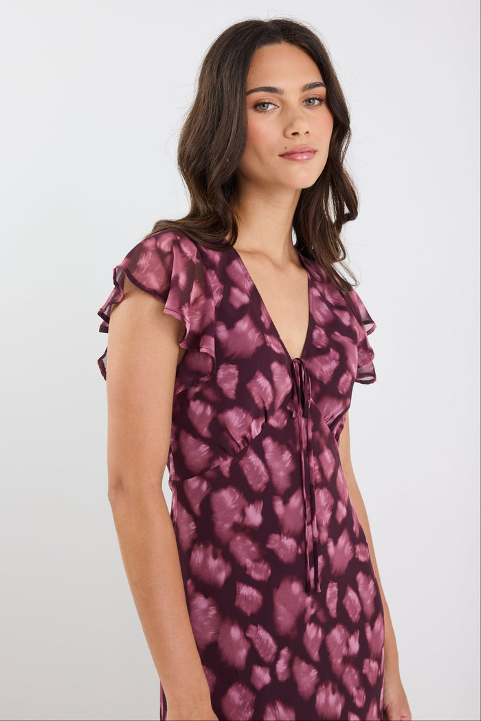 Woman wearing a purple floral dress against a white background