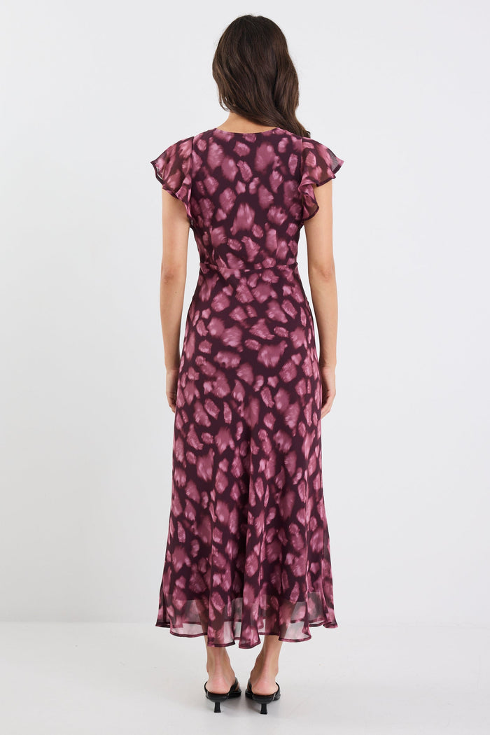 Woman wearing a purple floral dress against a white background