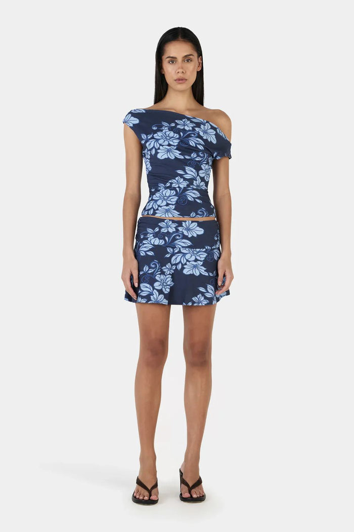 Woman wears a navy blue floral top and skirt