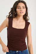 woman wearing a brown ruched top