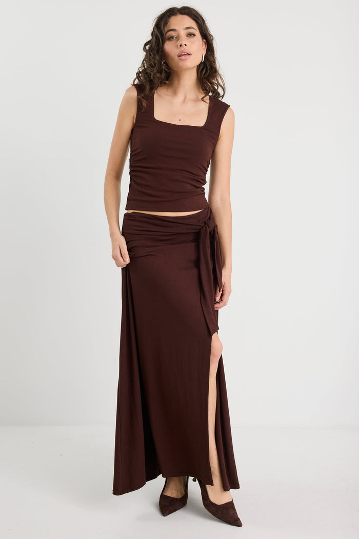 Woman wearing a brown ruched top and matching brown skirt