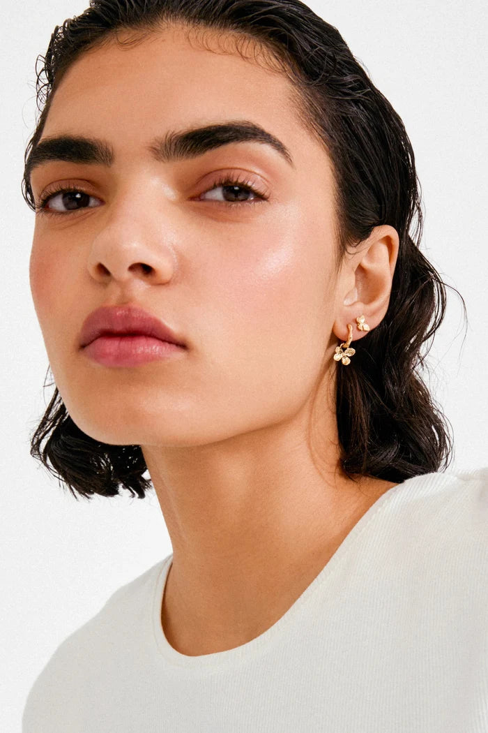 Woman wearing a white top with a plain background