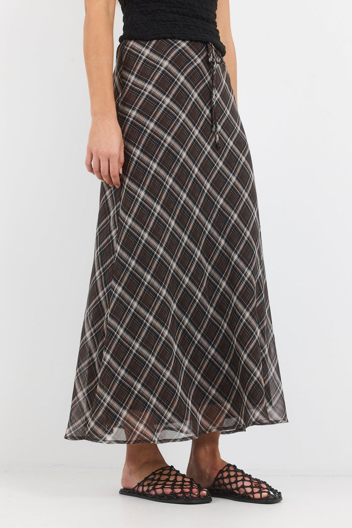 Person wearing a plaid skirt on a white background