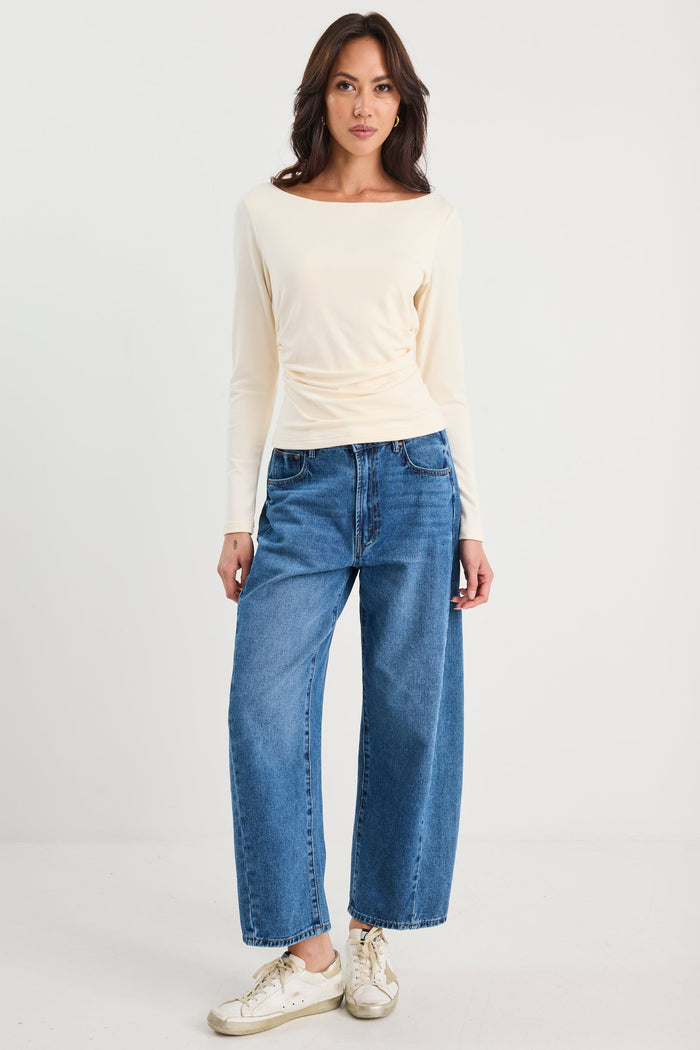 Woman wearing a ruched cream long sleeve top