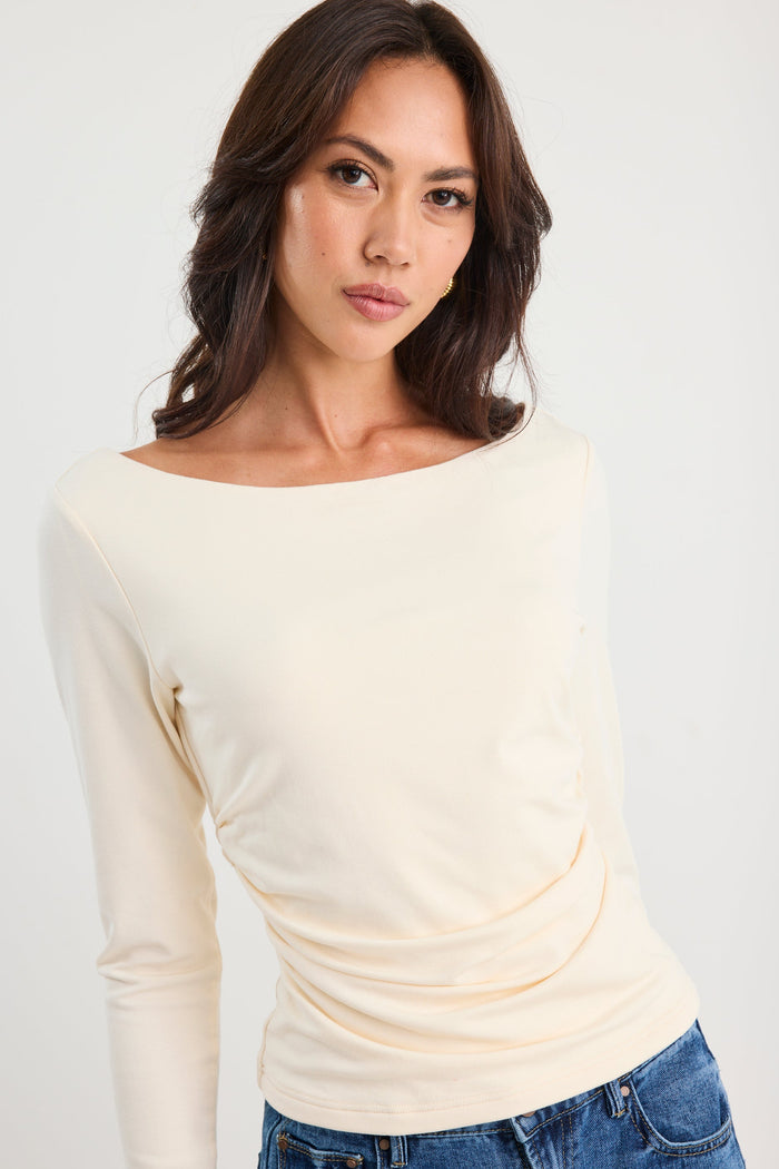 Woman wearing a ruched cream long sleeve top