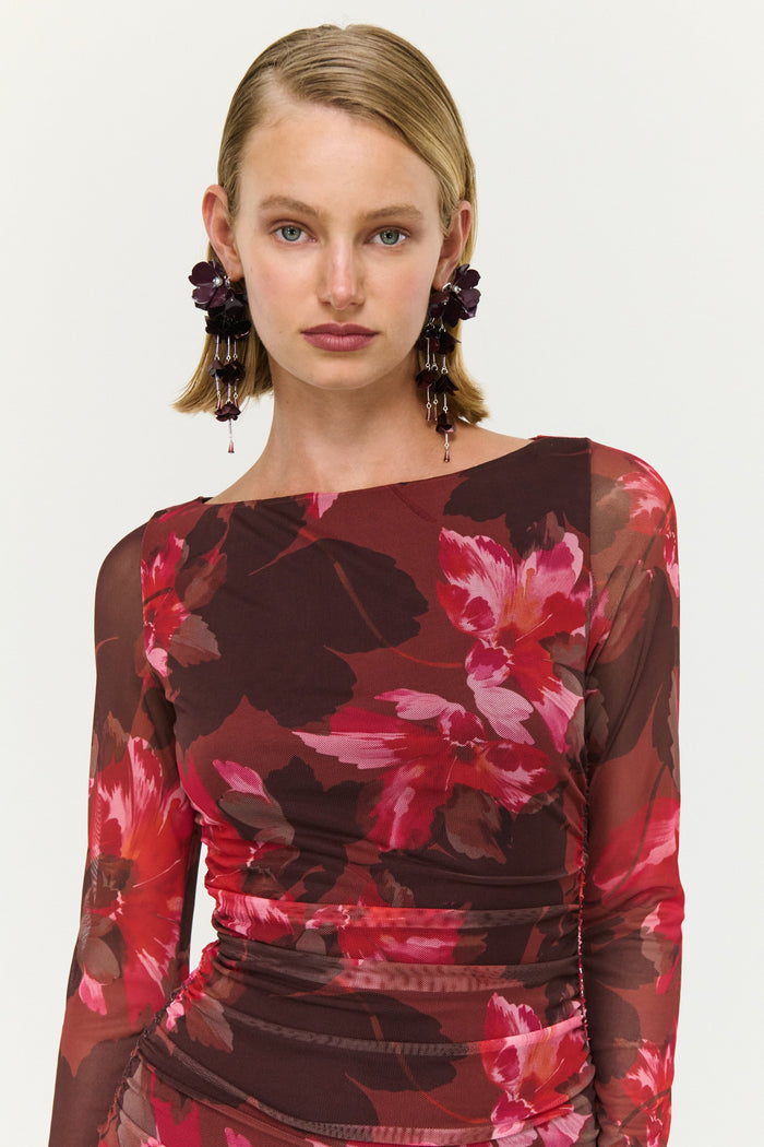 Woman wearing a red floral dress against a white background