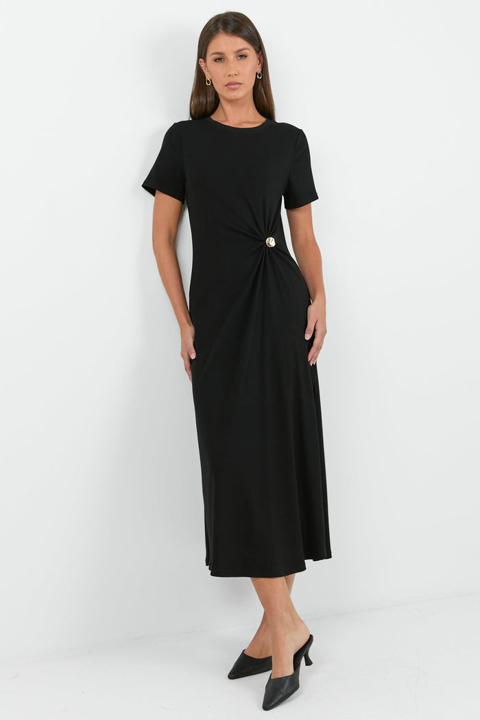 Woman wearing a black dress with a knot detail on a white background