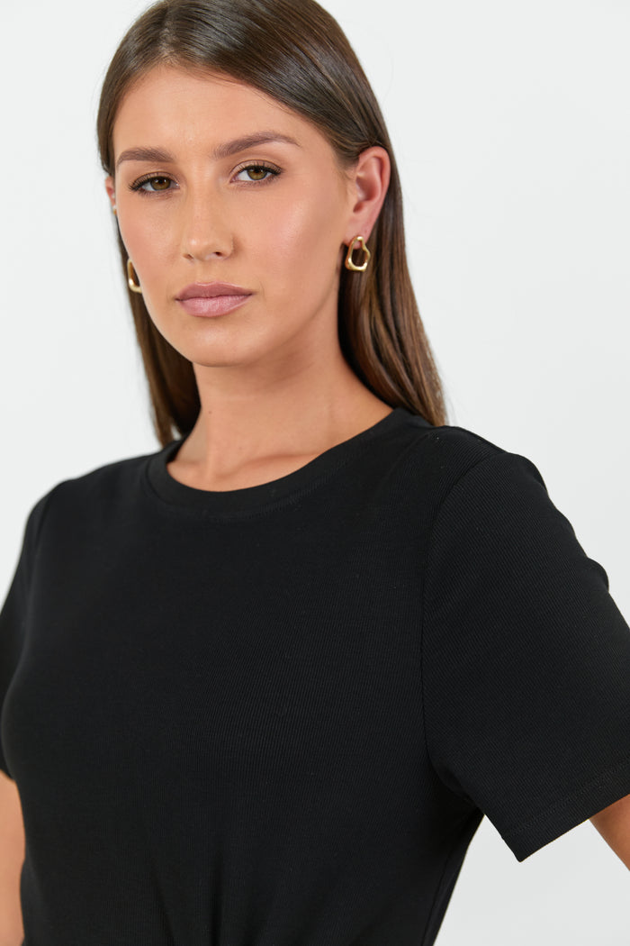 Woman wearing a black t-shirt against a plain background