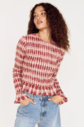 Woman wearing a red and white checkered shirt and blue jeans on a white background