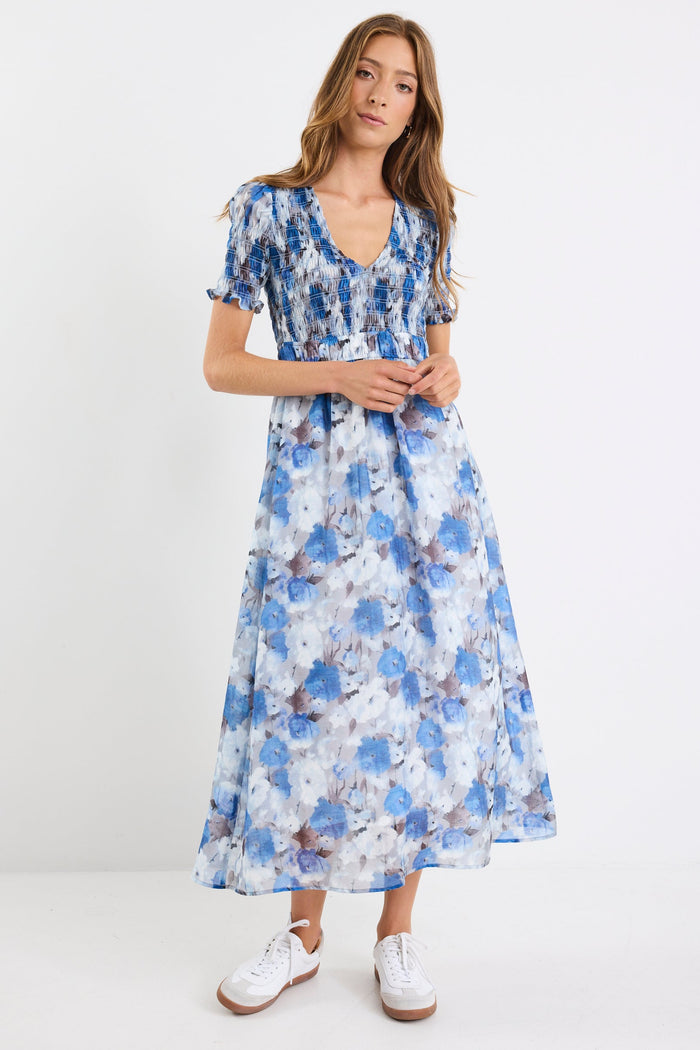 Woman wearing a blue floral dress on a white background