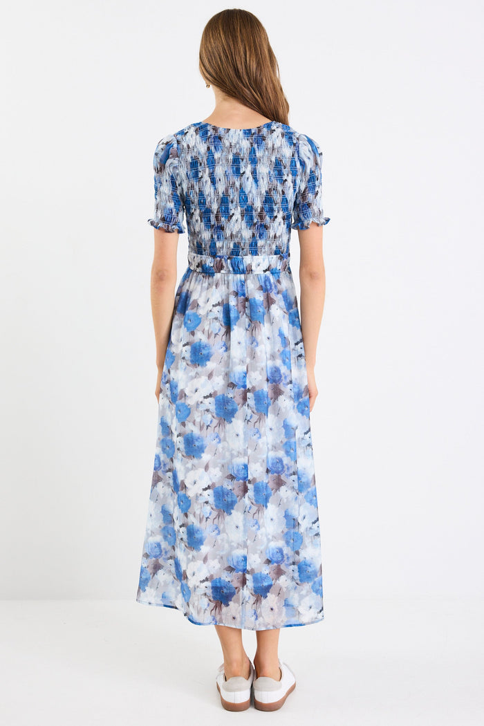 Woman wearing a blue floral dress on a white background
