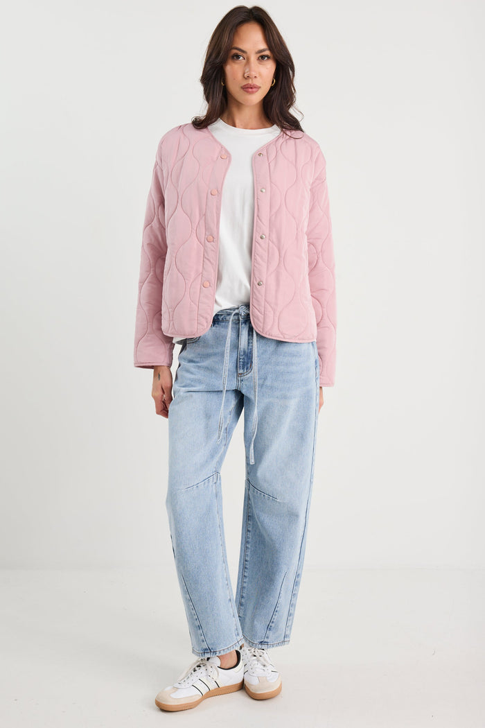 Woman wearing a pink quilted jacket and blue jeans