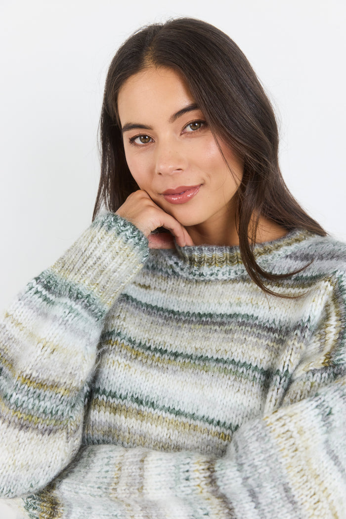 Woman wearing a striped sweater against a plain background