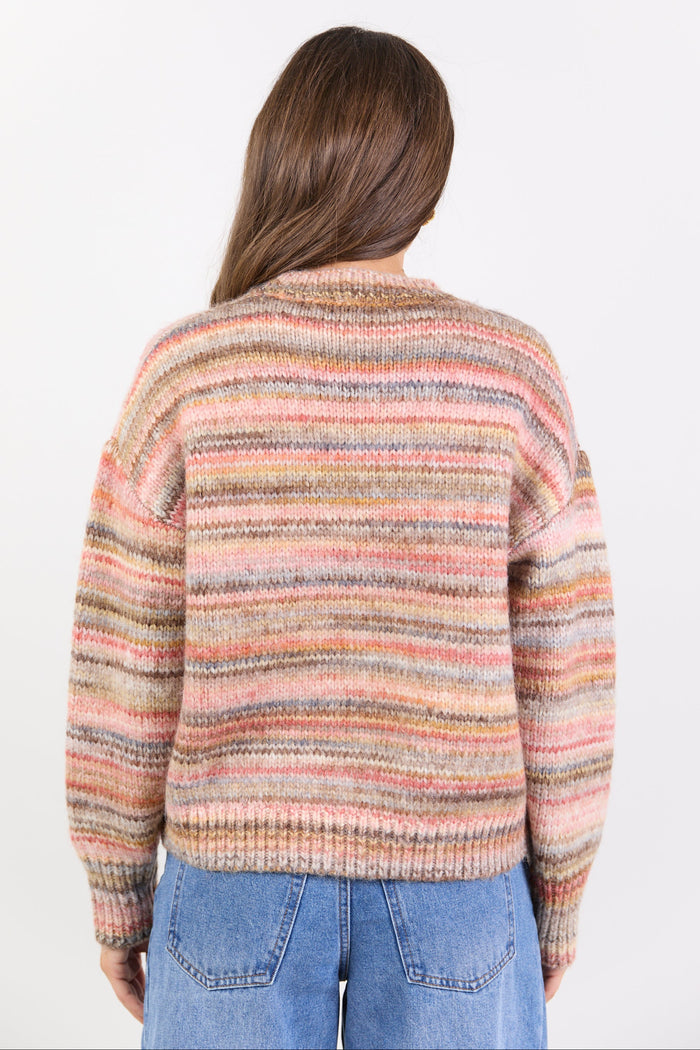 Person wearing a multicolored striped sweater on a white background
col_pattern