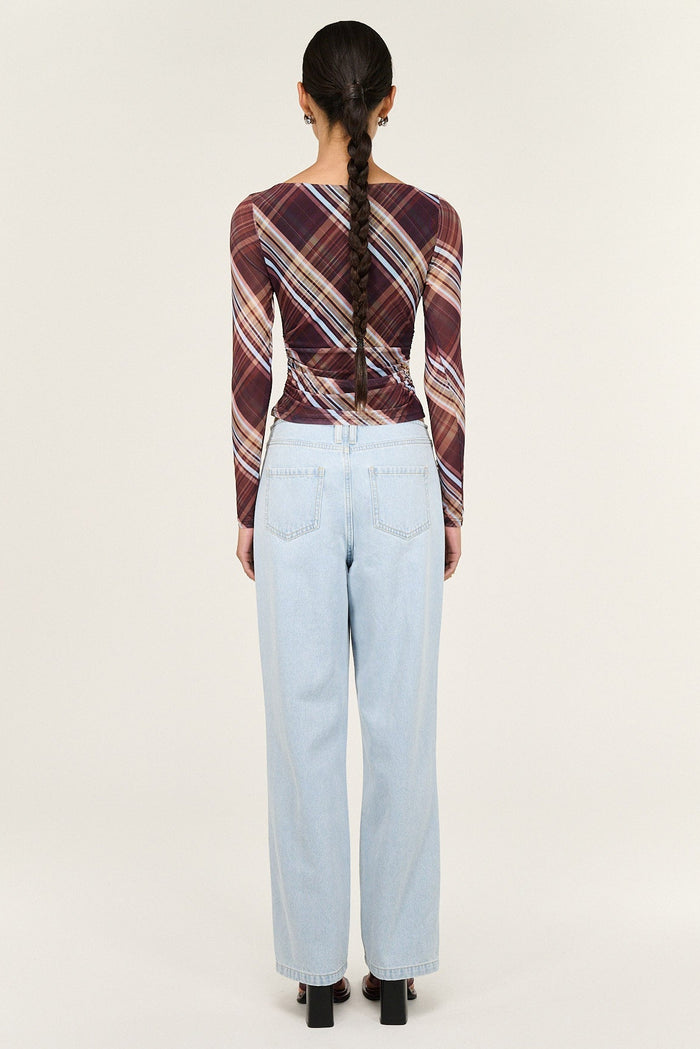 Person wearing a plaid shirt and light blue jeans from behind on a white background