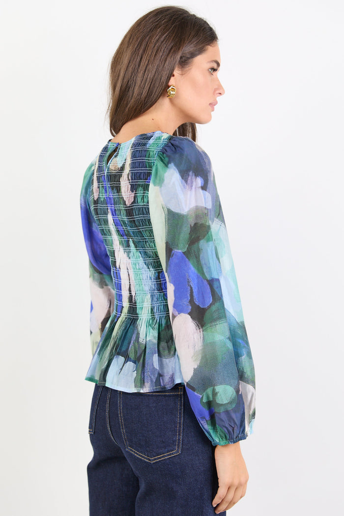Woman wearing a colorful floral blouse on a white background