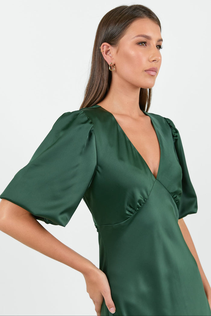 Woman wearing a green dress with short sleeves on a white background