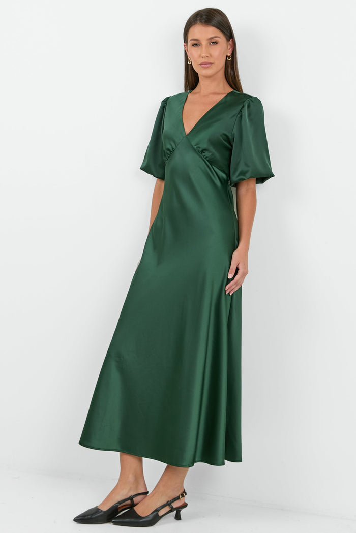 Woman wearing a green satin dress against a white background