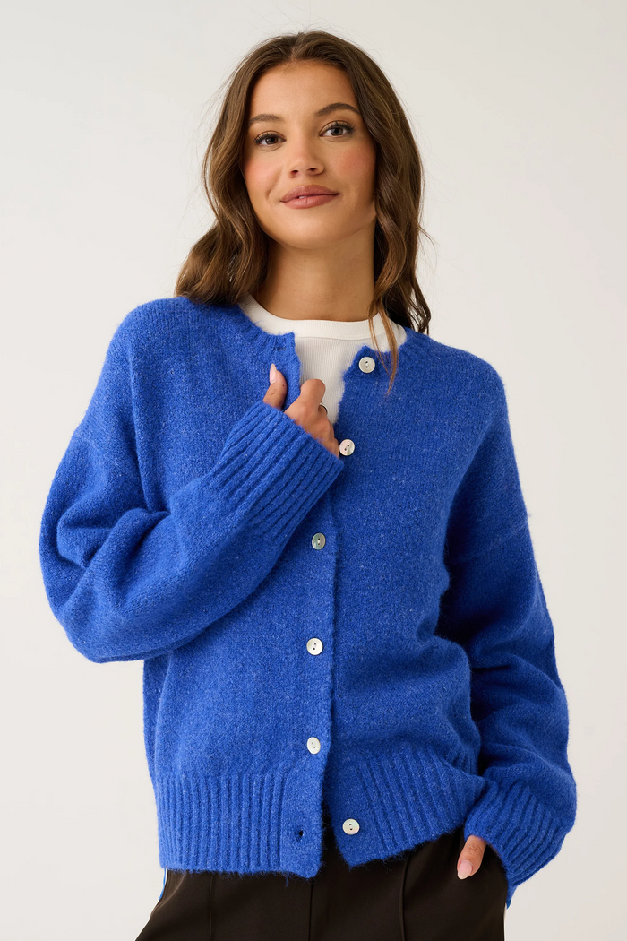 Woman wearing a blue cardigan on a white background