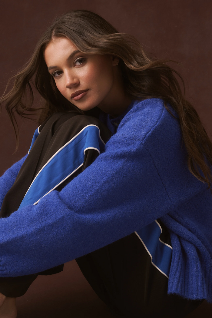 Woman wearing a blue sweater against a brown background
