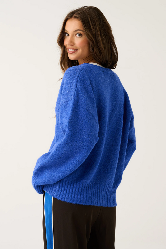 Woman wearing a blue sweater on a plain background