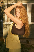 Model wears a brown shoulder bag by status anxiety