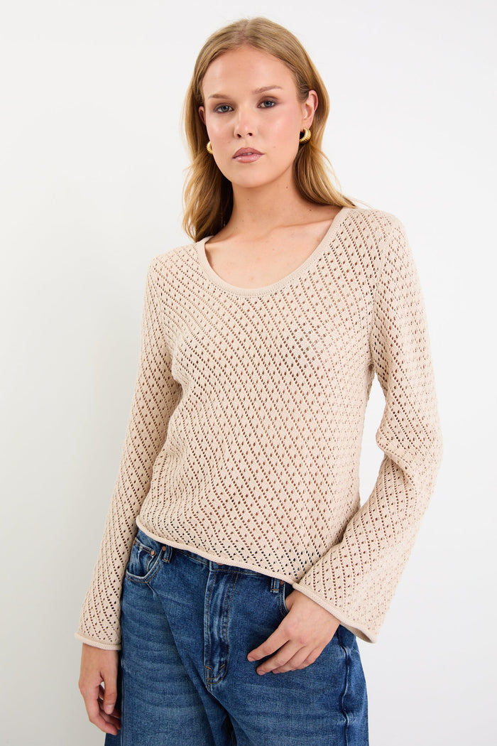 Woman wearing a light crochet knit and blue jeans