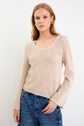 Woman wearing a light crochet knit and blue jeans