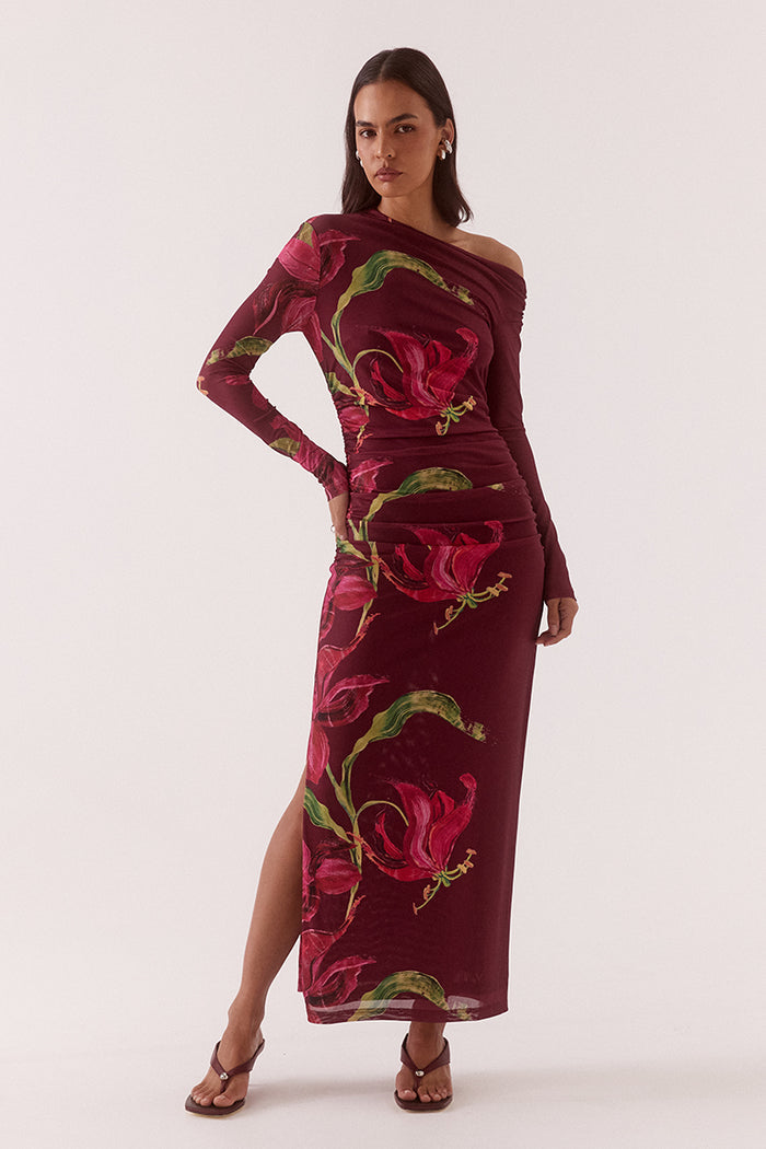 Woman wearing a burgundy dress with floral pattern on a white background