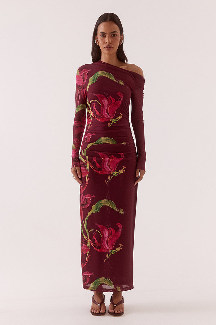 Woman wearing a burgundy off-shoulder dress with floral patterns on a white background