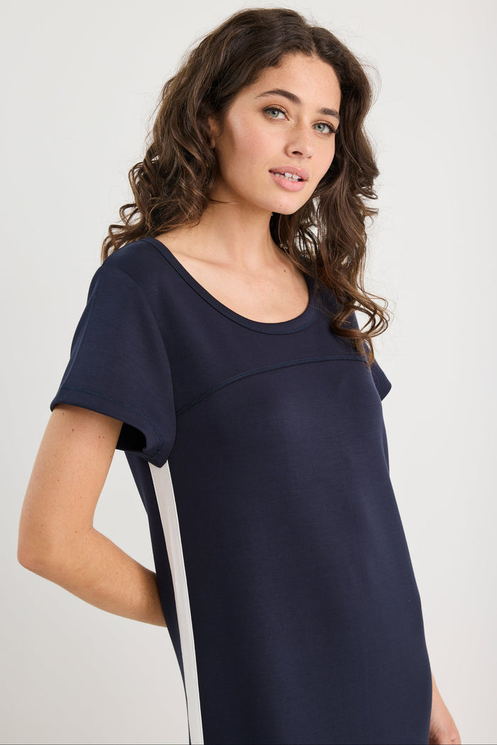 Woman wearing a navy blue dress against a white background