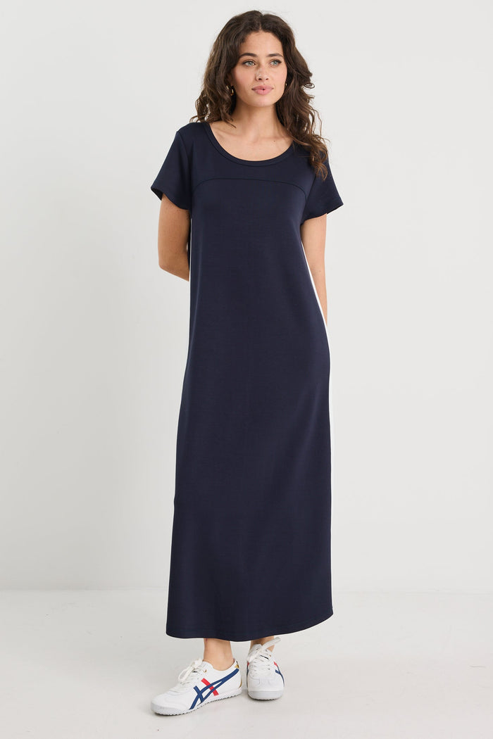 Woman wearing a long navy dress on a white background