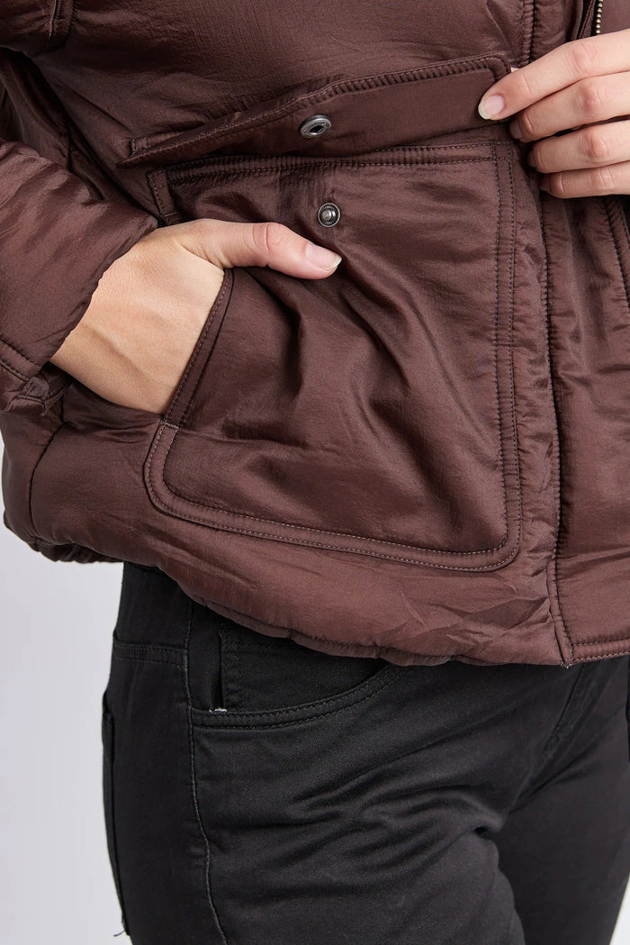 Brown jacket with a focus on the pocket area against a white background