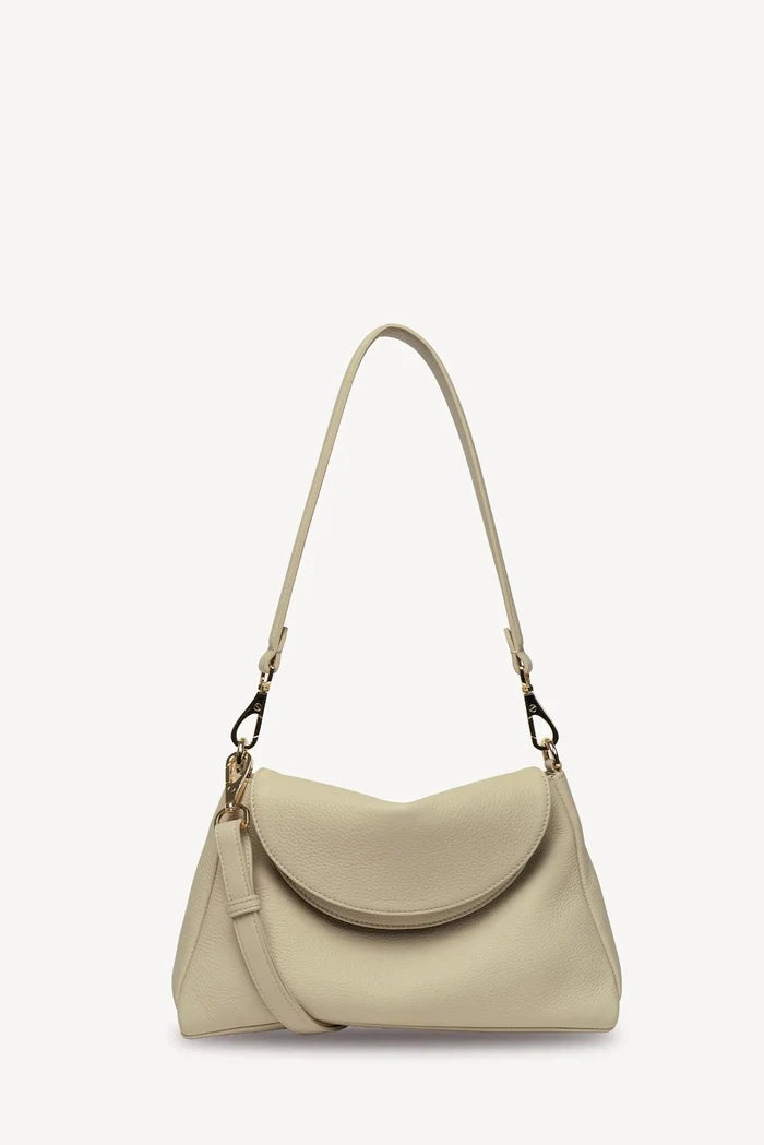 A light beige leather shoulder bag with a curved flap, a long shoulder strap, and a detachable crossbody strap, shown against a plain white background.
