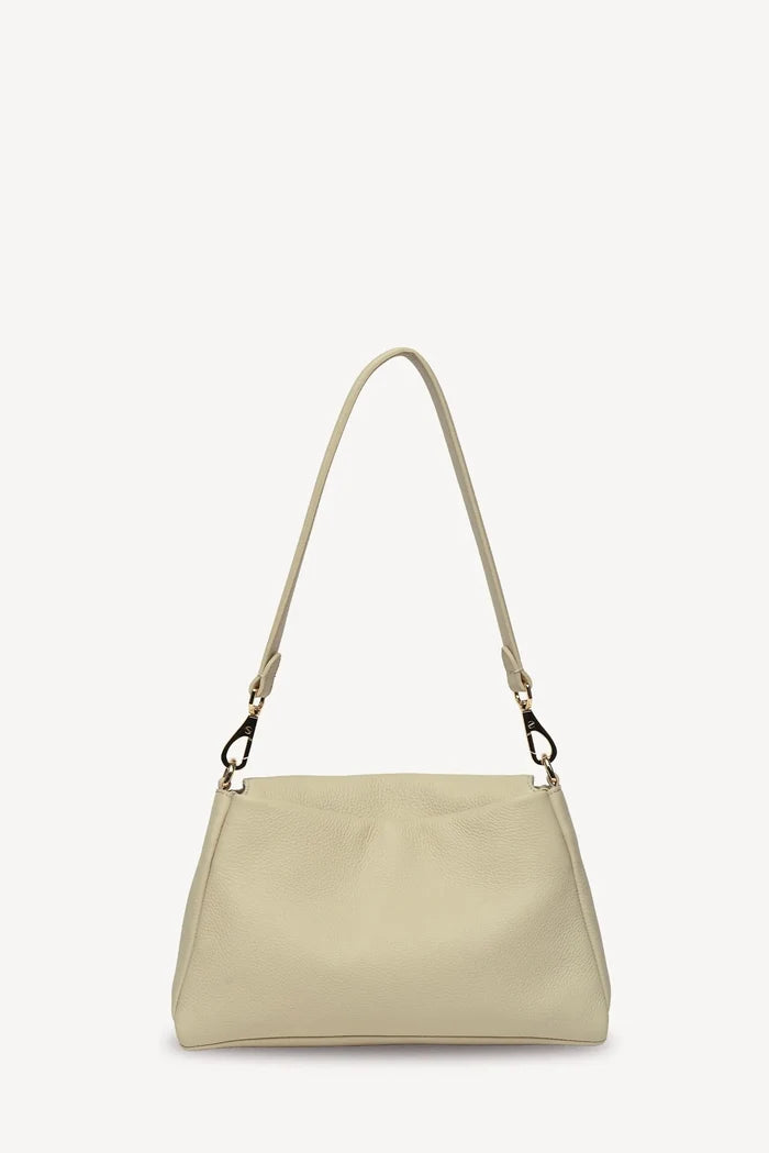 A light beige leather shoulder bag with a matching adjustable shoulder strap and gold-tone hardware, shown against a plain off-white background.