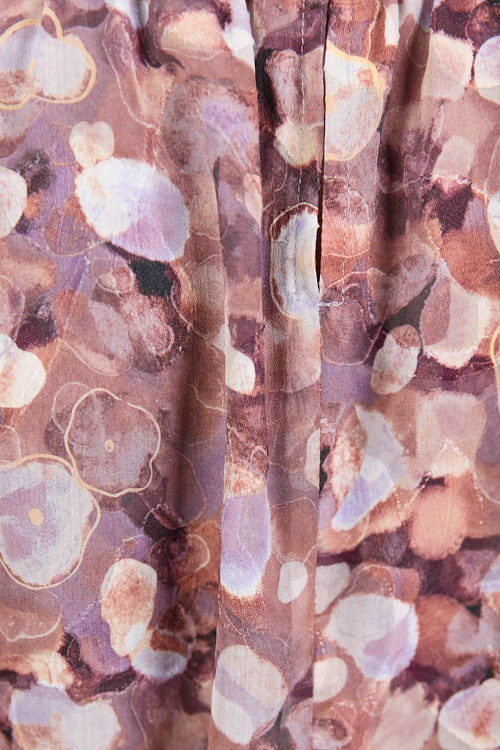 Close-up of a fabric with a floral pattern in shades of brown, pink, and white.
