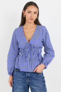 Woman wearing a blue and white striped blouse with long sleeves on a white background