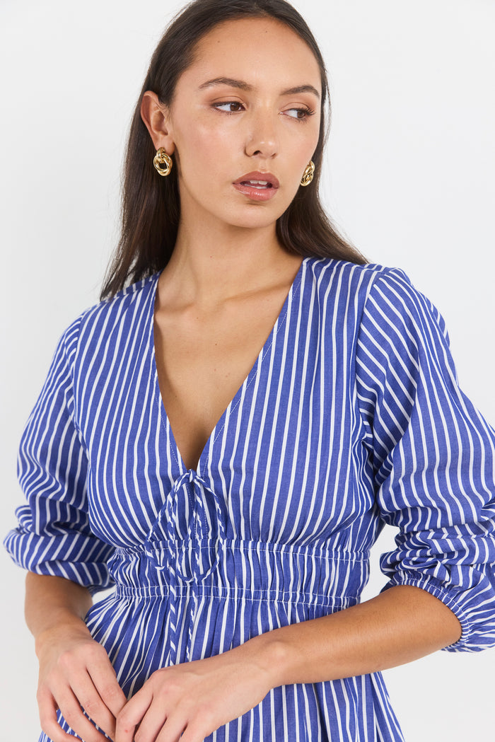 Woman wearing a blue and white striped top against a white background