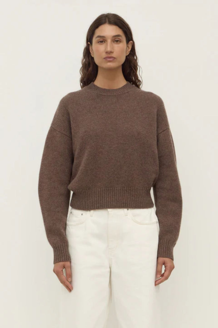 woman wears a brown knit cardigan