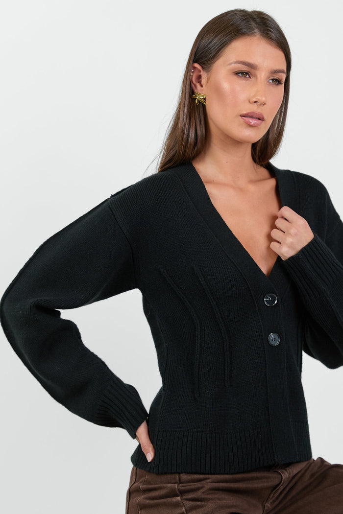 Woman wearing a black cardigan against a white background